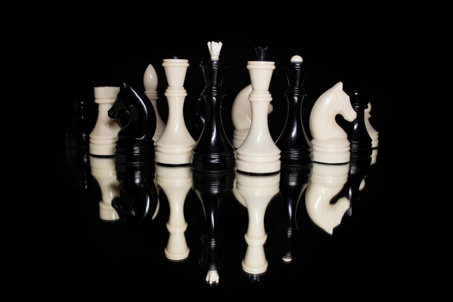 屏幕特写：战棋棋盘上两方单位以不同颜色标记，蓝色方前排两名承伤单位挡住红色方推进路线，后排输出单位头顶显示技能覆盖的三格范围